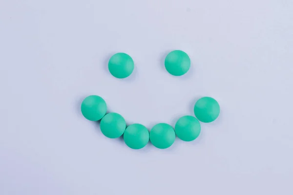 Smiley gemaakt van groene ronde pillen geïsoleerd op wit. — Stockfoto
