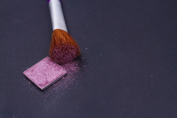 Arrossire o cipria ombretto rosa cipria e pennello su sfondo nero. — Foto Stock