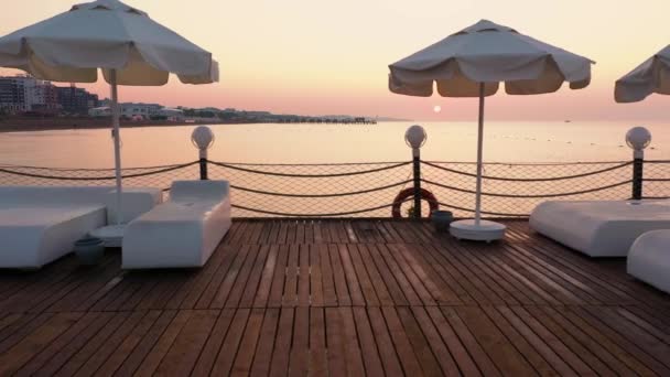 サンラウンジャー付き木製の桟橋の夕景. — ストック動画