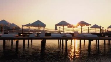 Gün batımında sakin deniz suyuyla iskele arkaplanı.