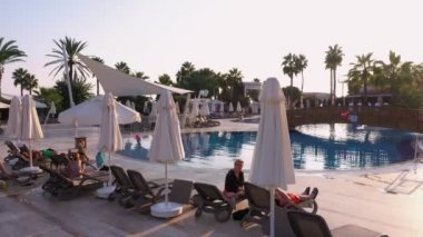 Palmiye ağaçları ile yüzme havuzu manzarası.