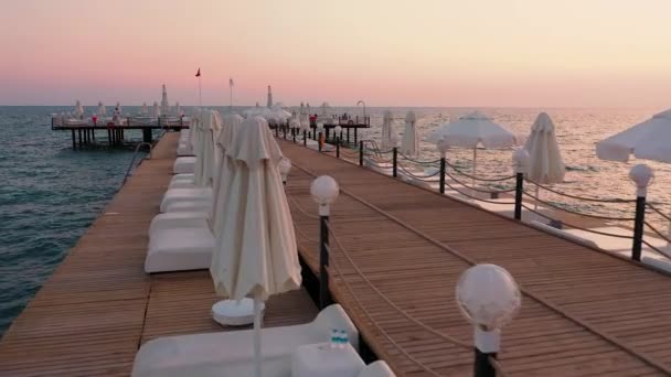 Muelle en el mar ondulado en el fondo del cielo puesta del sol. — Vídeo de stock