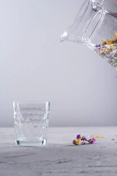 A kancsó vizet önt az üvegpohárba.. — Stock Fotó