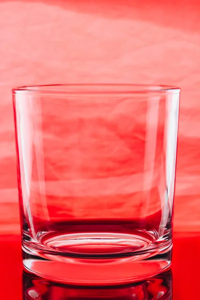 Liten glas på röd bakgrund. — Stockfoto