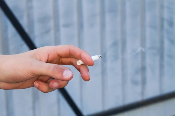 Adolescente chico fumando cigarrillo al aire libre en el patio . — Foto de Stock