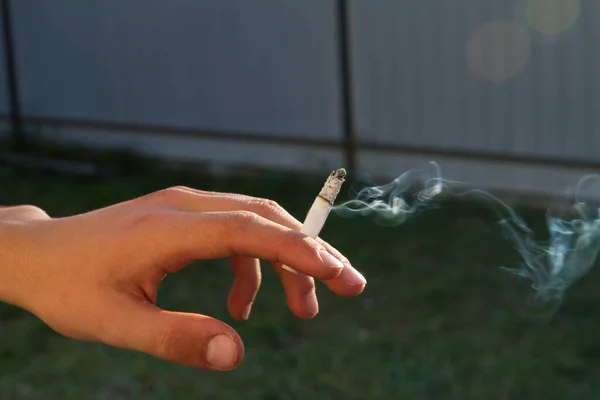 青少年在户外手拿着香烟. — 图库照片