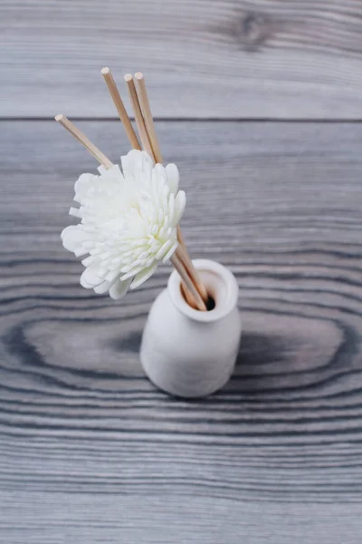 Διακοσμητικό λουλούδι spa σε λευκό βάζο σε γκρι ξύλινο φόντο. — Φωτογραφία Αρχείου
