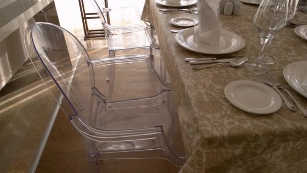 Close-up zicht op tafel en stoelen geserveerd in de woonkamer. — Stockvideo