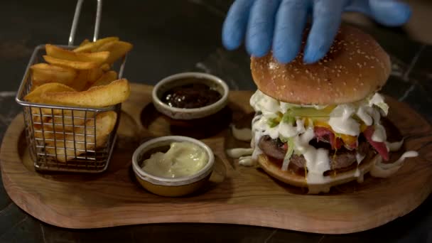 Chef-kok handen maken gastronomische hamburger. — Stockvideo