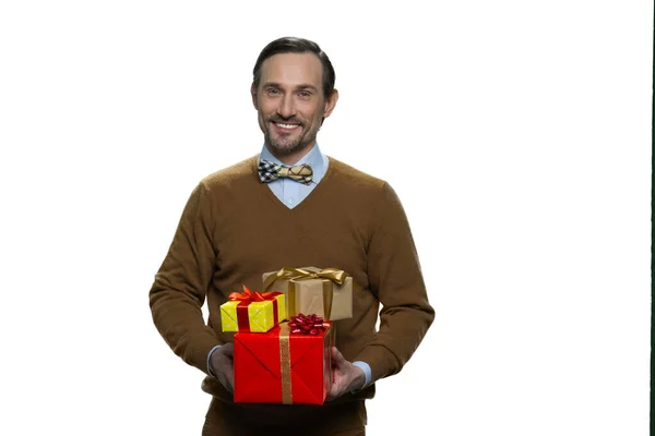 Sorrindo homem maduro está segurando uma pilha de presentes . — Fotografia de Stock