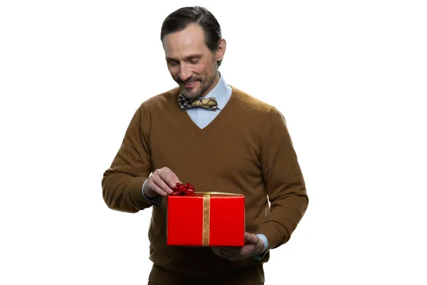 Atraente homem de meia-idade abrindo a caixa de presentes . — Fotografia de Stock