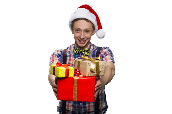 Portret van een vrolijke lachende jongen geeft je cadeaudozen voor kerst. — Stockfoto