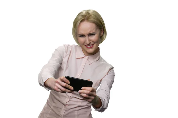 Excited mature woman playing video games on her smartphone. — Stock Photo, Image