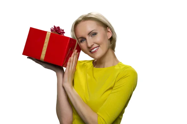Gioiosa bella donna in piedi con scatola regalo rossa sullo sfondo bianco. — Foto Stock
