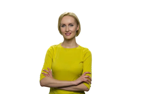 Mujer sonriente en cuello alto amarillo con brazos cruzados sobre fondo blanco . — Foto de Stock