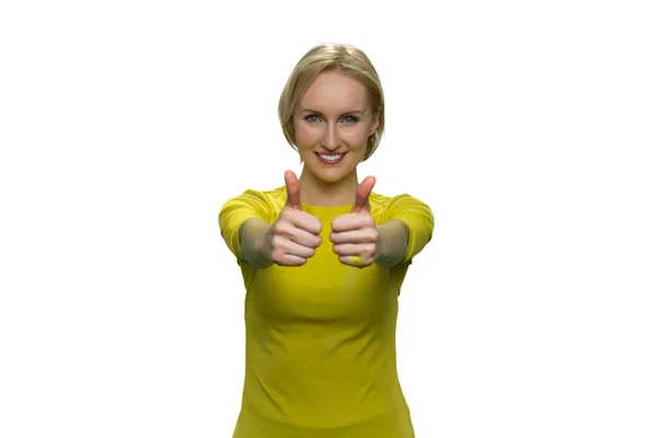 Happy woman in yellow showing okay with both hands on white background. — Stock Photo, Image