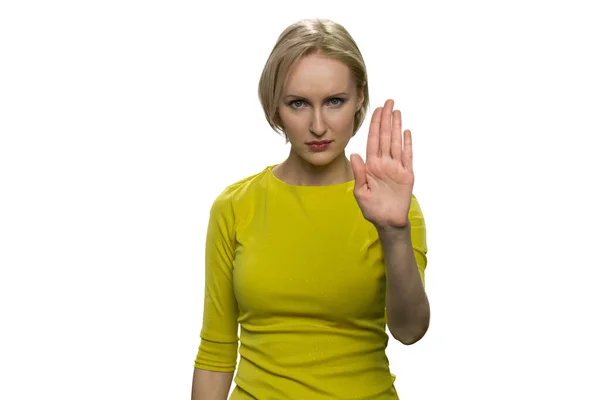 노란 터틀넥을 입은 진지 한 젊은 여성이 손바닥으로 정지 동작을 하는 모습. — 스톡 사진