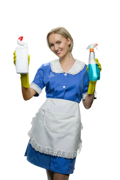 Sonriente criada sosteniendo en spray limpiador de manos y desinfectante de inodoro levantando las manos sobre fondo blanco . —  Fotos de Stock