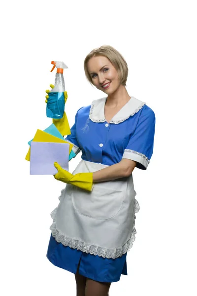 Empregada loira em luvas de borracha amarela demonstrando spray mais limpo e espanadores no fundo branco . — Fotografia de Stock