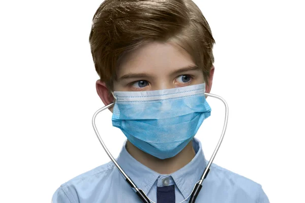Портрет мальчика в медицинской маске и стетоскопе. — стоковое фото