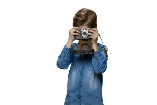 Маленький мальчик фотографирует с помощью ретро-камеры. — стоковое фото