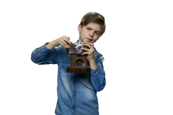 Teenage boy in denim clothes is making a shot with retro camera. — Stock Photo, Image