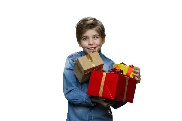 Kot elbiseli genç çocuk elinde beyaz arka planda bir sürü hediye kutusu tutuyor.. — Stok fotoğraf