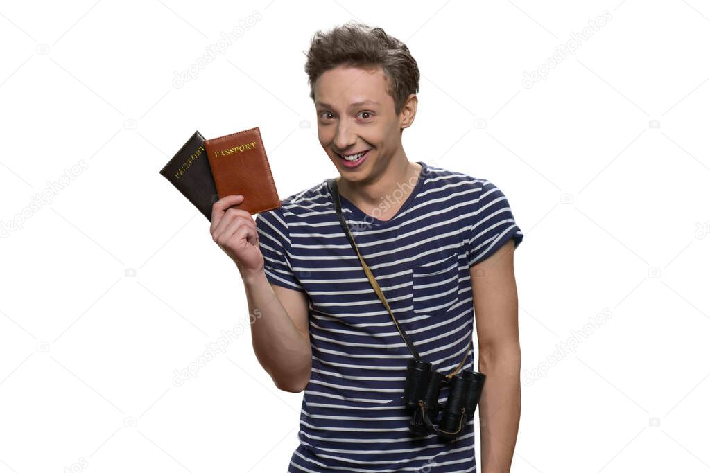 Portrait of smiling teenage travaler holding passports.
