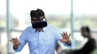 Sanal gerçeklik gözlüğü takan korkmuş genç bir adam..