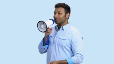 Renk arkaplanı olarak megafon kullanan Hintli adam.