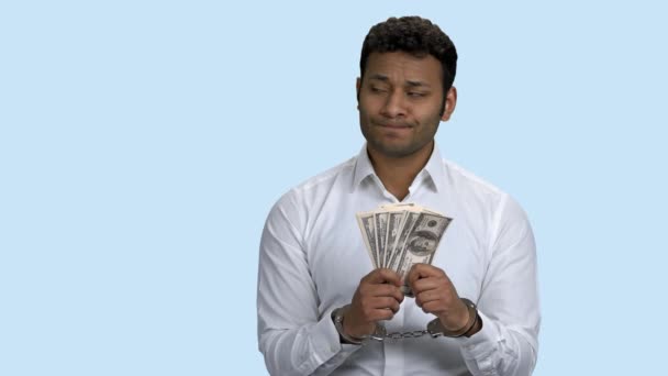 Бизнесмен в наручниках держит взятку в долларах. — стоковое видео