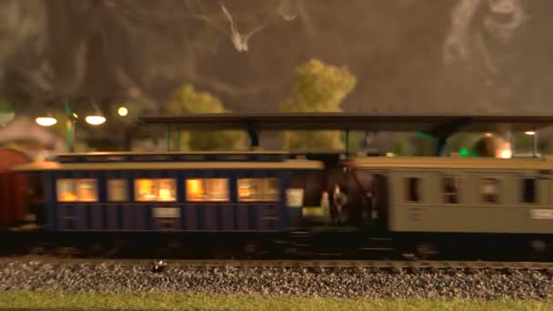 Modell-Dampflokomotive aus nächster Nähe fährt durch den Bahnhof. — Stockvideo