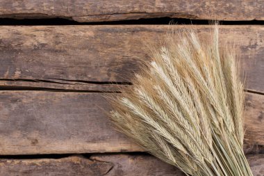 Tahta arka planda olgunlaşmış mısır gevreği kulakları..