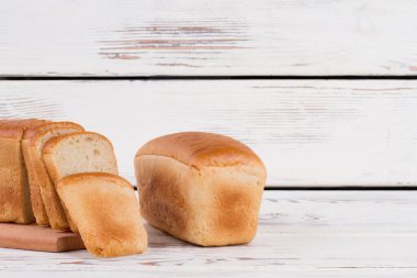 Ahşap zeminde tam ve dilimlenmiş ekmek..