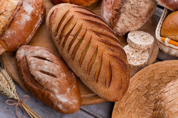 Assortimento di pane al forno su fondo tavola in legno. — Foto Stock