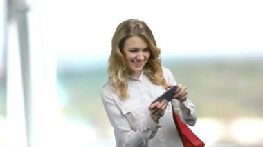 Bulanık arkaplanda cep telefonu uygulaması oyunu oynayan kadın.