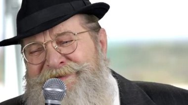 Bulanık arka planda mikrofonu olan sakallı adamı kapat..