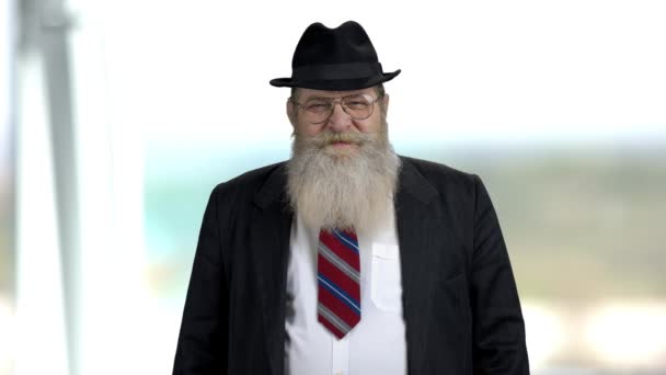 Старший бородатый бизнесмен на размытом фоне — стоковое видео