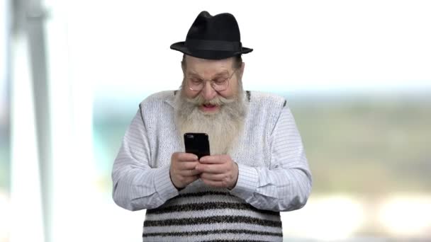 Divertente pensionato caucasico utilizzando il telefono cellulare. — Video Stock