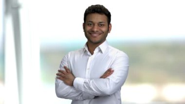 Bulanık arka planda gülümseyen koyu tenli adam.