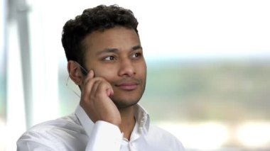 Neşeli Hintli adam fütürist şeffaf telefonla konuşuyor..