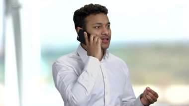 Kendine güveni tam bir iş adamı cep telefonuyla konuşuyor..