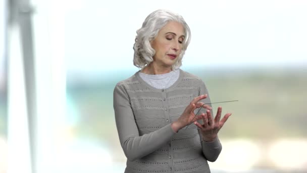 Femme âgée utilisant une tablette numérique en verre. — Video