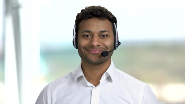 Operador de centro de llamadas sonriente sobre fondo borroso. — Vídeos de Stock