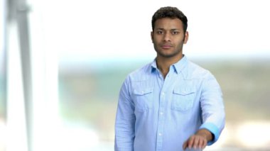 Kendine güveni olan genç bir adam elleriyle jest yapıyor..