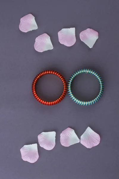 Deux bracelets et pétales de fleurs. — Photo