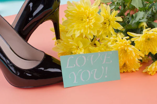 黒いハイヒールの靴と黄色の花が閉じます. — ストック写真
