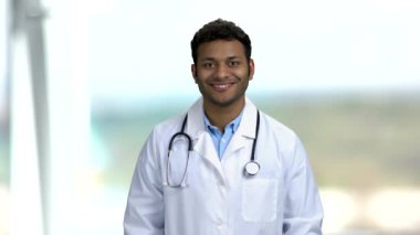 Genç Hintli doktor baş parmağını gösteriyor..