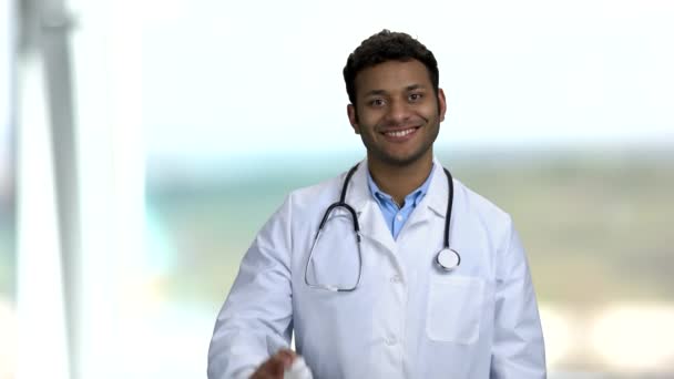 Junger lächelnder Arzt empfiehlt Pillen. — Stockvideo