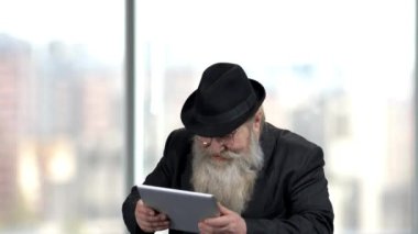 Neşeli sakallı adam dijital tablette oyun oynuyor..